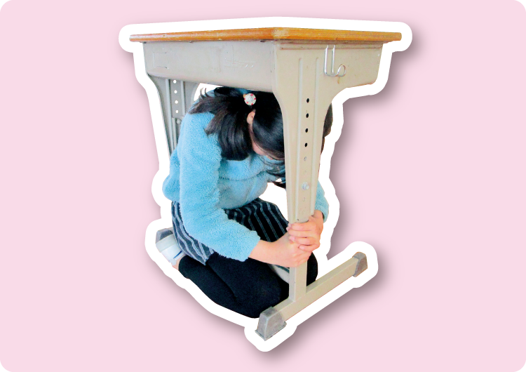 机の下に入って頭を守る写真1