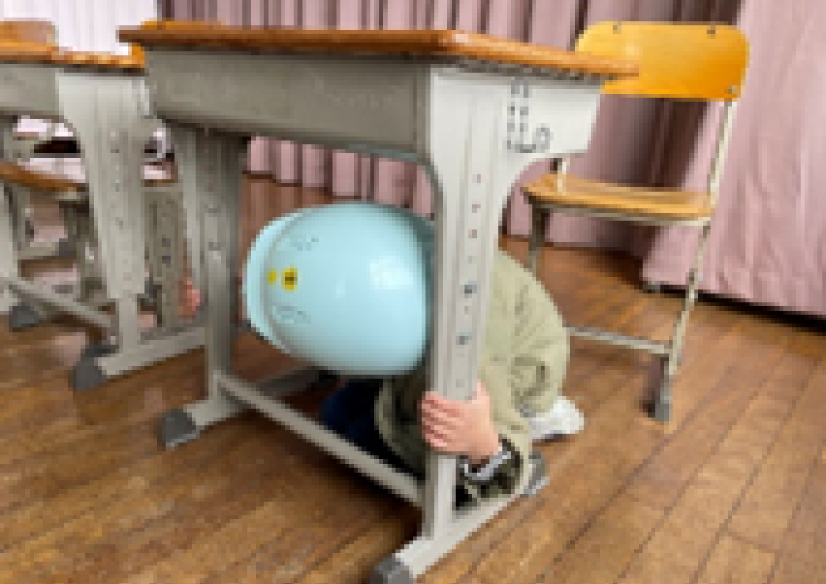 机の下に入って頭を守る写真3