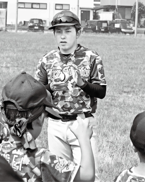 小学生に野球を教える石井さん