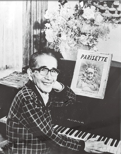 ピアノの前の白井鐵造さん