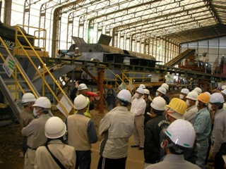 破砕した災害廃棄物を選別する設備の説明を受ける住民